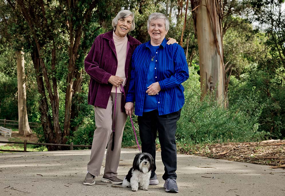 Jo Ann and Pat standing outside with their Havanese dog, Darcy